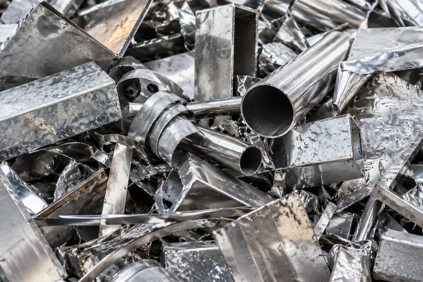 Close-up of clean new production offcuts: tubes, box sections and chequer plate.